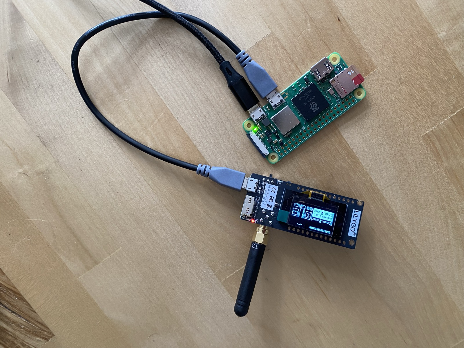 A Raspberry Pi Zero 2 W wired to a LILYGO LoRa radio with its antenna attached, sitting on a workbench. The Mayfly sensor board is not installed yet.