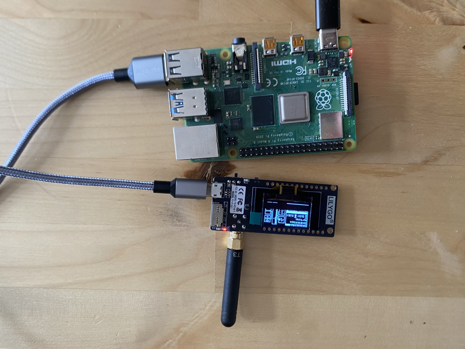 A Raspberry Pi 4 wired to a LILYGO LoRa radio with its antenna attached, sitting on a workbench.
