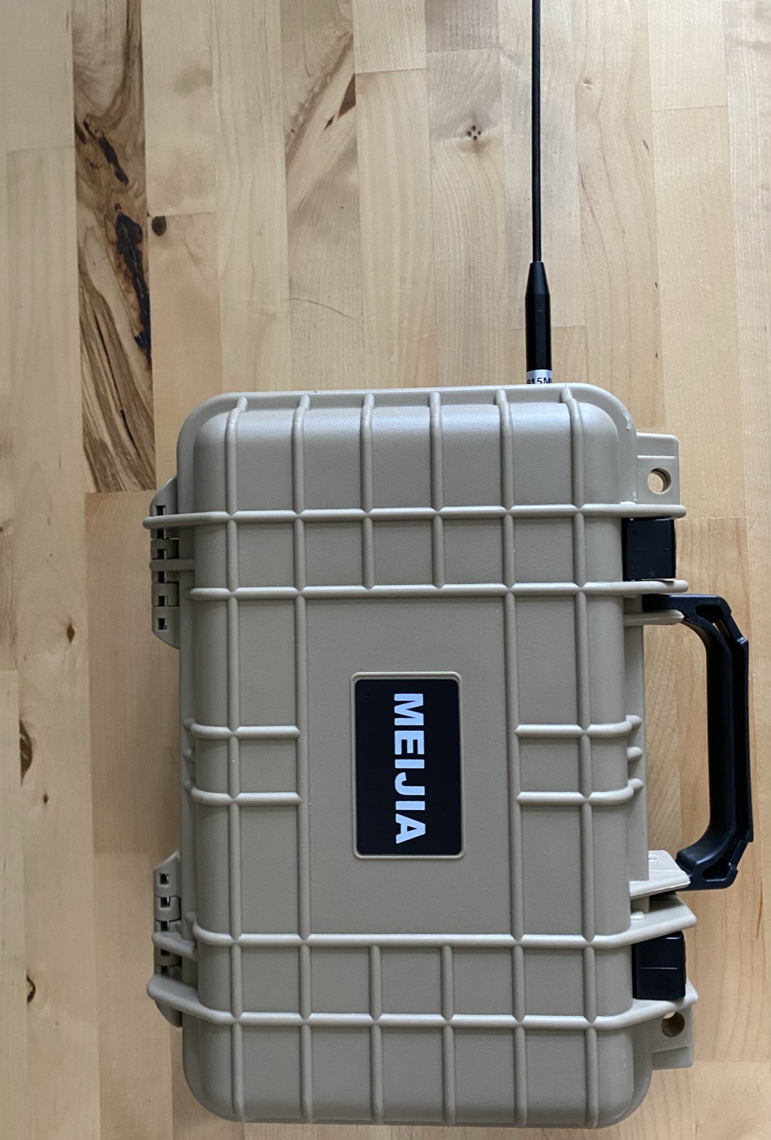 The same node sealed in its tan waterproof case, with the 915 MHz antenna mounted through the top of the case on a bulkhead.