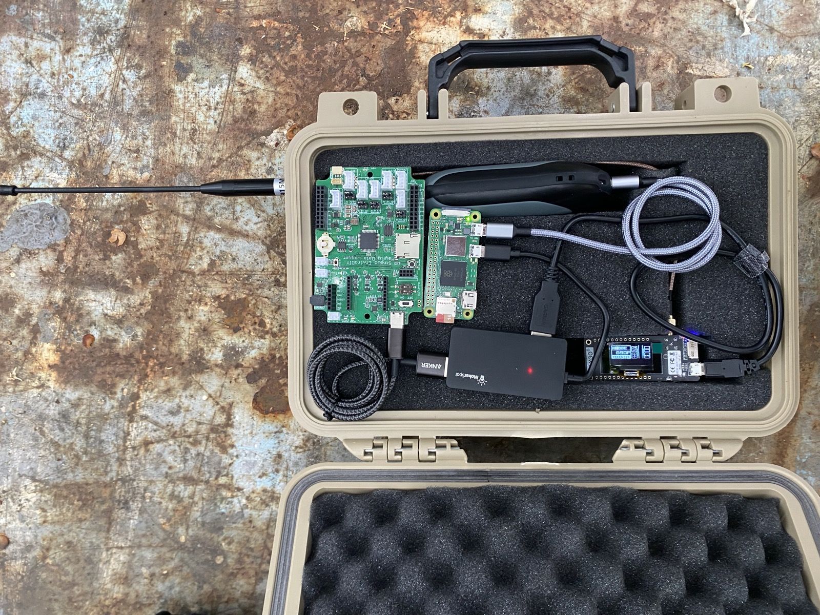 The v0.5 leaf in an open tan waterproof case: a Raspberry Pi, an EnviroDIY Mayfly, a LoRa radio with its 915 MHz antenna, and a USB battery bank, foam-mounted.